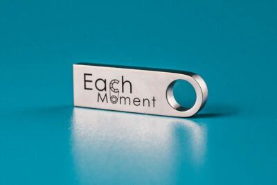 EachMoment Standard USB Memory Stick: 8cm long metallic silver casing with EachMoment in black font.